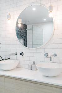 a bathroom with two sinks and a mirror at Poinciana House—Luxury Noosa Retreat close to Beach in Noosa Heads