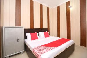 a bedroom with a bed with red and white pillows at Flagship 13088 Hotel Basant in Rāja Sānsi