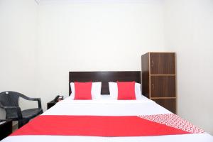 a bedroom with a large bed with red and white pillows at Flagship 13088 Hotel Basant in Rāja Sānsi