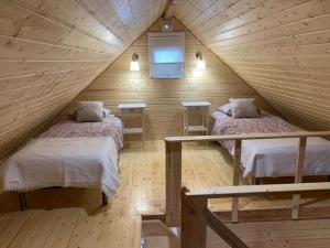 a bedroom with two beds in a wooden attic at Giżycko-Przerwanki Domki Widok na Mazury in Giżycko