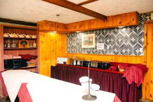 a kitchen with wooden walls and a table in a room at Travels Inn Victoria County in Boularderie East