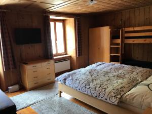 a bedroom with a bed and a tv and bunk beds at Apartment Verena in Vals