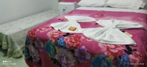 uma cama com duas toalhas brancas em cima em Pousada Canto das Araras - Vila Bom Jardim Nobres MT em Nobres