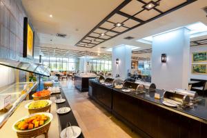a large kitchen with a buffet line in a restaurant at Pinnacle Lumpini Park Hotel in Bangkok