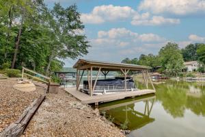 ein Boot mit einem Pavillon auf dem Wasser in der Unterkunft Lakefront Hot Springs Vacation Rental with Dock! in Hot Springs Village