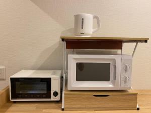 a microwave and a toaster oven on a table at AJITO Hostel & CafeBar in Shingu