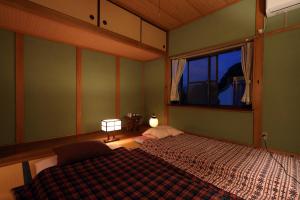 um quarto com uma cama e uma janela em ゲストハウス 瀬戸内ライフ em Kure