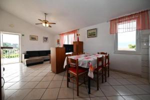 sala de estar con mesa, sillas y sofá en Apartments Mihovilovic - 50 m from beach en Slatine