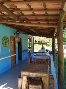 pérgola de madera con mesas y bancos en el patio en Casa Tulum, en Barra Grande