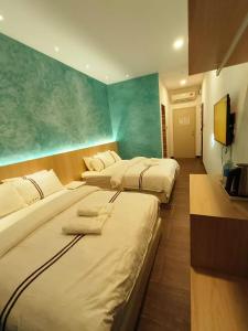 um quarto de hotel com duas camas e uma televisão de ecrã plano em Red's Hotel em Bintulu