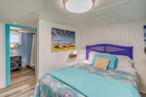 a bedroom with a bed with a blue head board at Colorful Murrells Inlet Gem with Outdoor Space! in Myrtle Beach