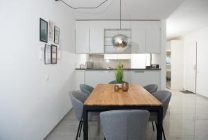 eine Küche und ein Esszimmer mit einem Holztisch und Stühlen in der Unterkunft Apartment La Riva 105 Lenzerheide with an indoor Pool in Lenzerheide