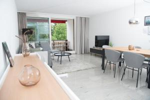 salon ze stołem, krzesłami i kanapą w obiekcie Apartment La Riva 105 Lenzerheide with an indoor Pool w mieście Lenzerheide
