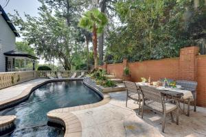 a swimming pool with a table and chairs next to a house at Chic Georgia Getaway with Pool and Deck, Near Beaches! in Savannah