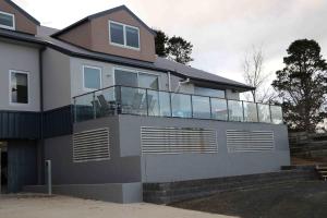 a house with a balcony with chairs on it at Snowhaven in Jindabyne
