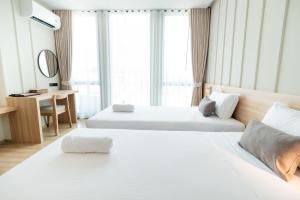 Habitación de hotel con 2 camas y escritorio en Pillows boutique hotel en Chiang Mai