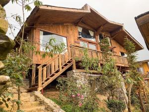 una casa de madera con una escalera que conduce a ella en Cloud Forest Tà Xùa, en Bắc Yên