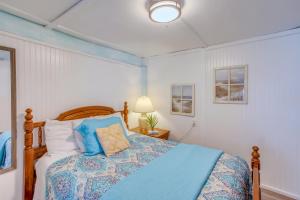 a bedroom with a bed with a blue comforter at Murrells Inlet Apartment with Direct Beach Access! in Myrtle Beach