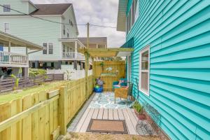a porch with a blue house and a wooden fence at Murrells Inlet Apartment with Direct Beach Access! in Myrtle Beach