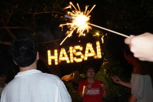 a person holding a sparkler in front of a sign at 秘密基地 NO's ARROW ノーズアロー in Onna