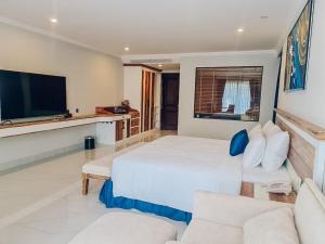 a bedroom with a bed and a couch and a tv at VIP Bãi Sau Villages in Vung Tau