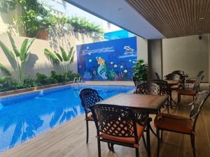 a restaurant with a table and chairs next to a swimming pool at VIP Bãi Sau Villages in Vung Tau