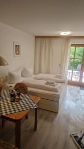 a bedroom with a large bed and a table at Haus Rottachbrücke May in Tegernsee