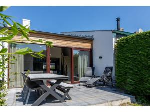 een picknicktafel en stoelen op een patio bij Attractive holiday home, sunny garden, 150 meters from the beach in Nieuwvliet-Bad