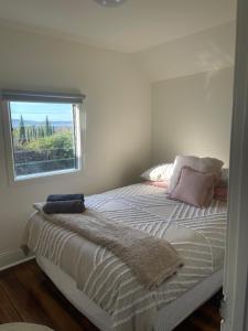 a bedroom with a bed with a window at Heritage Cottage in Sandy Bay in Sandy Bay