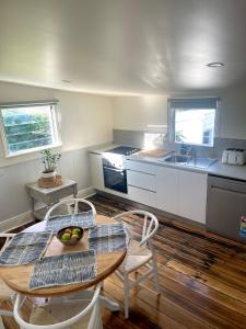 a kitchen with a table and chairs and a kitchen with a sink at Heritage Cottage in Sandy Bay in Sandy Bay