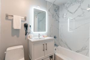 a white bathroom with a sink and a mirror at Inn on Broadway in San Francisco