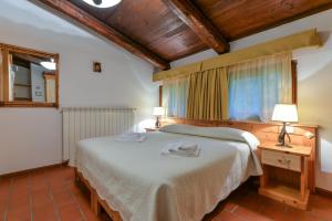 a bedroom with a large bed in a room with wooden ceilings at 28- Cantele House in Tuscany - Feste&Sagre - Relax e Sport in Castel del Piano +46 photos