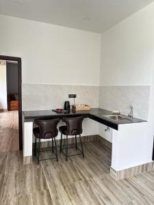 a kitchen with a counter with two chairs and a sink at ili-ah ki in Dimāpur