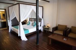 Un dormitorio con una cama con dosel y un sofá. en SinQ Beach Morjim, en Morjim 98 fotos más
