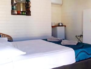 uma cama num quarto com duas toalhas em Burdekin Motor Inn em Home Hill