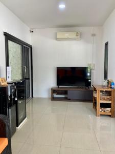 a living room with a flat screen tv and a couch at DUDU'S HOSTEL in Koh Tao