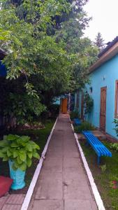 una acera frente a un edificio azul con un banco azul en гостевой дом "Бумеранг KG", en Cholpon-Ata