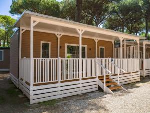 瑪里納羅米亞的住宿－Sole Family Camping Village，一座带门廊和楼梯的小木房子