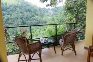 a balcony with two chairs and a table with a view at Welcome Inn in Ella