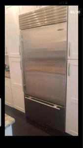 a stainless steel refrigerator in a kitchen with white cabinets at Fleet st Property in Baltimore