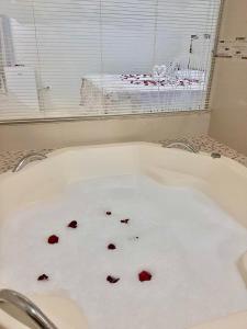 a bath tub with red hearts in it at Bela Casa Hostel in Ji-Paraná