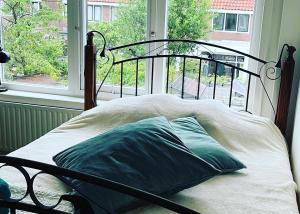 a bed sitting in a room with a window at BeBaBops Homestay Utrecht in Utrecht