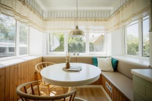 un tavolino e sedie in una stanza con finestre di Nautika Central Residence a Kuressaare