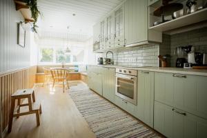 - une cuisine avec des placards blancs, une table et des chaises dans l'établissement Nautika Central Residence, à Kuressaare