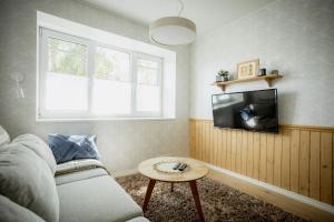 a living room with a couch and a tv at Nautika Central Residence in Kuressaare