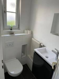 een witte badkamer met een toilet en een wastafel bij Schöne 2 Zimmerwohnung in Heusenstamm in Heusenstamm