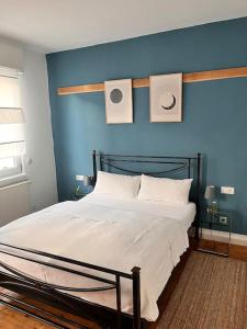 een slaapkamer met een bed met een blauwe muur bij Schöne 2 Zimmerwohnung in Heusenstamm in Heusenstamm