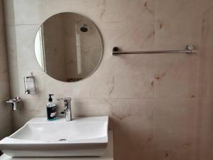 a bathroom with a sink and a mirror at Green Cottage Oriental in Panchkula