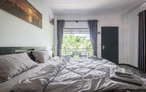 1 cama grande en un dormitorio con ventana en The Botanic Garden Hotel en Siem Reap