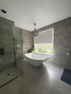 ein Bad mit einer Badewanne und einem Fenster in der Unterkunft Envisage Estate in Cambridge